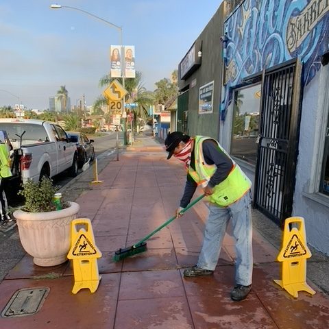 Clean & Safe Crew member washing the sidewalk