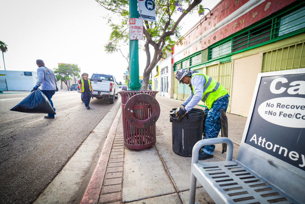 Clean & Safe team member removing trash from street