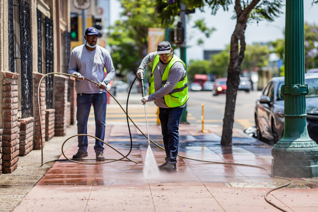 Clean & Safe Crew members power washing sidewalk