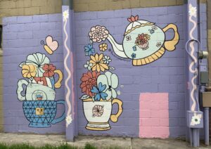 colorful wall mural depicting a teapot pouring flowers into a teacup.