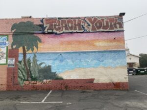 Urban mural depicting a beach scene with Palm Trees.