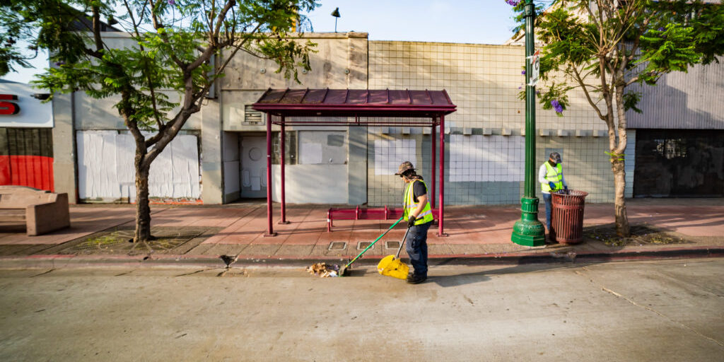 Clean & Safe team member cleaning a bus shelter along University Avenue
