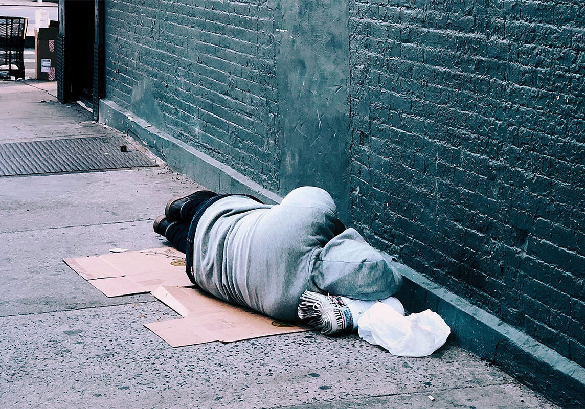 Homeless person asleep on the sidewalk